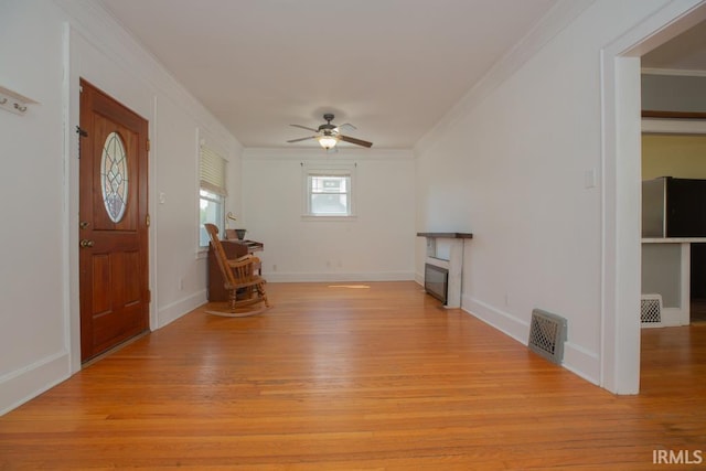 entryway featuring light hardwood / wood-style flooring, ceiling fan, and crown molding