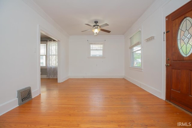 entrance foyer featuring ceiling fan, crown molding, and light wood-type flooring