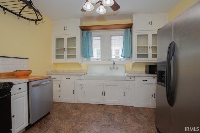 kitchen with white cabinets, dishwashing machine, stainless steel refrigerator with ice dispenser, dark tile flooring, and ceiling fan