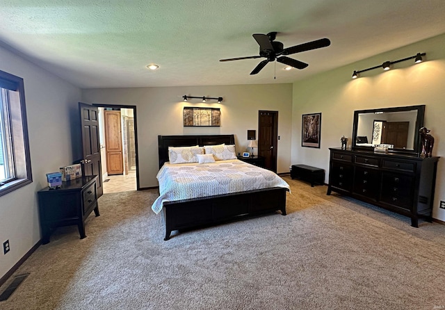 carpeted bedroom featuring ceiling fan and a textured ceiling