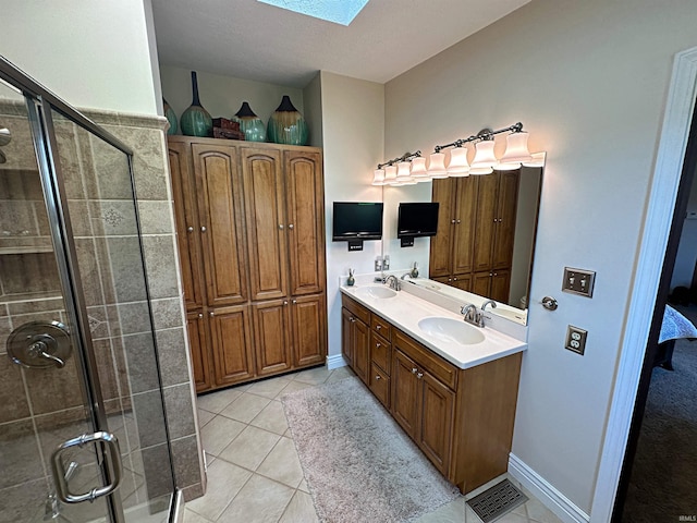 bathroom with a skylight, an enclosed shower, tile floors, and dual vanity