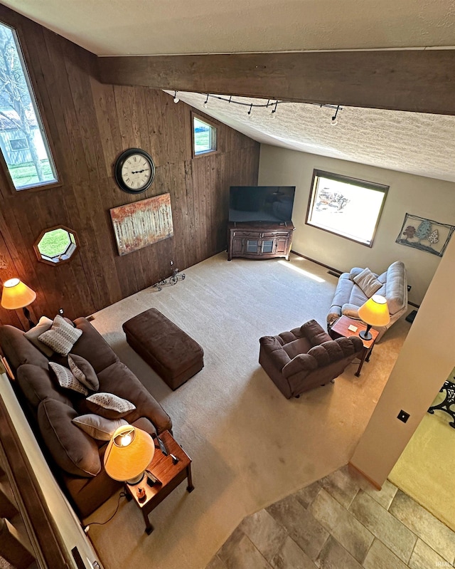 tiled living room featuring lofted ceiling, wooden walls, and a textured ceiling