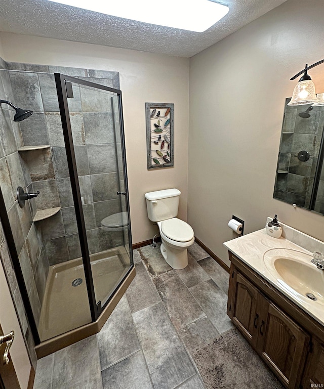 bathroom featuring a shower with door, toilet, tile flooring, a textured ceiling, and vanity