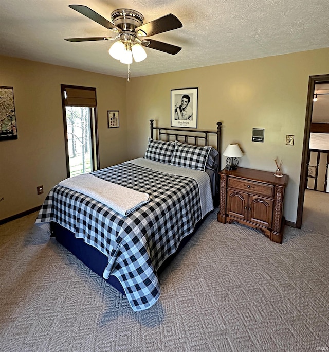 carpeted bedroom with ceiling fan and a textured ceiling