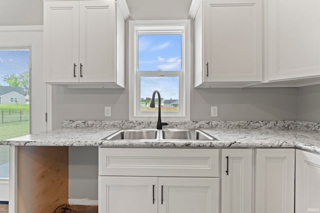 kitchen with sink, a wealth of natural light, and white cabinetry