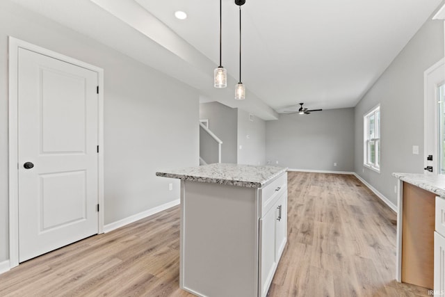 kitchen featuring a center island, white cabinetry, light hardwood / wood-style flooring, pendant lighting, and ceiling fan