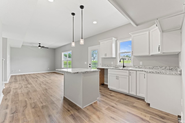 kitchen featuring light hardwood / wood-style flooring, white cabinets, decorative light fixtures, sink, and ceiling fan