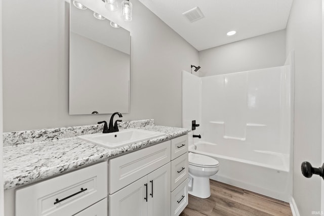 full bathroom with wood-type flooring, shower / bath combination, vanity, and toilet