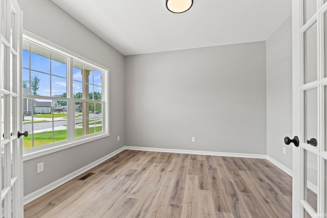 empty room featuring light hardwood / wood-style flooring and french doors