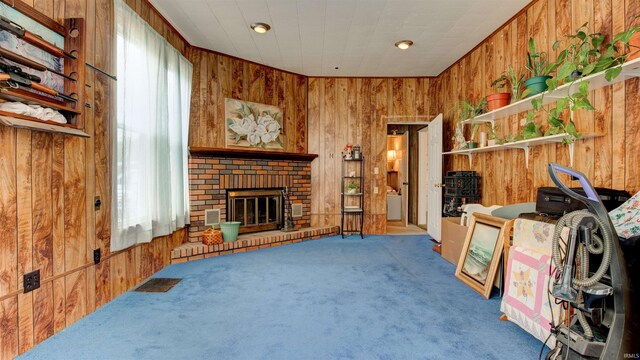 interior space featuring wood walls, carpet flooring, and a fireplace