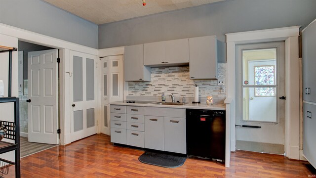 kitchen featuring black dishwasher, backsplash, and hardwood / wood-style flooring