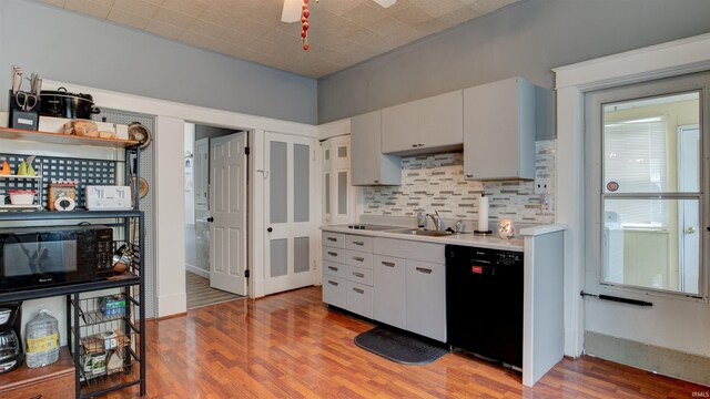 kitchen featuring backsplash, dishwasher, white cabinetry, hardwood / wood-style floors, and sink