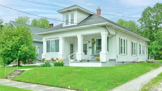 view of front of home with covered porch and a front yard