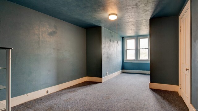 unfurnished room with a textured ceiling and carpet