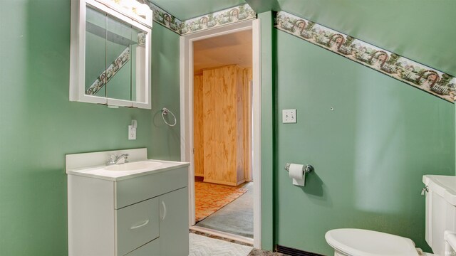 bathroom with tile flooring, vanity with extensive cabinet space, and toilet