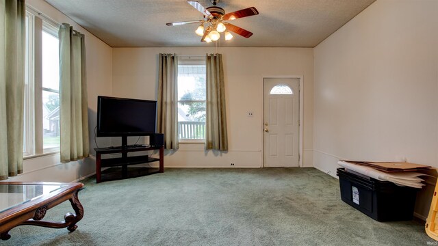 interior space featuring ceiling fan, a healthy amount of sunlight, carpet flooring, and a textured ceiling