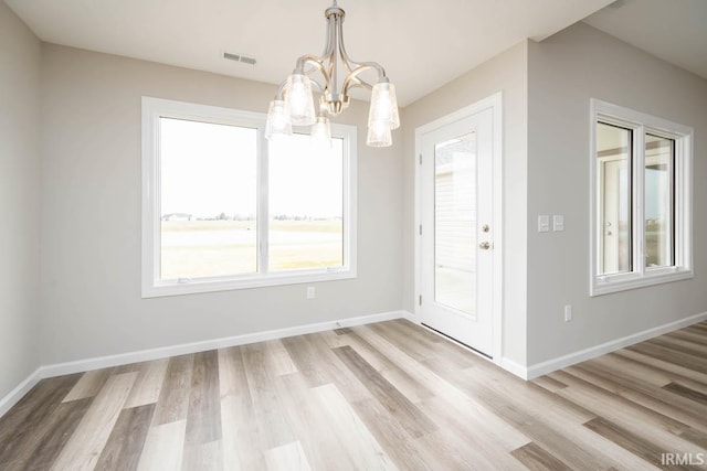 interior space with light hardwood / wood-style floors and an inviting chandelier