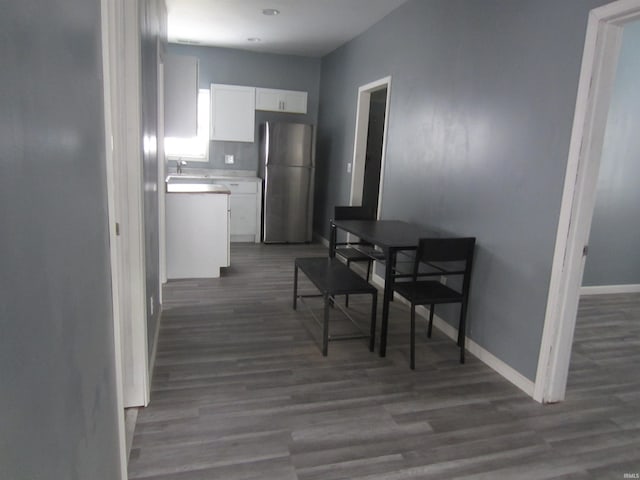 kitchen with white cabinets, dark hardwood / wood-style floors, sink, and stainless steel refrigerator