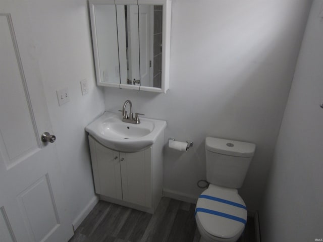 bathroom featuring wood-type flooring, vanity, and toilet