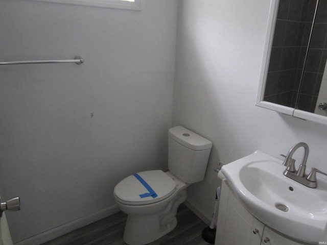 bathroom featuring vanity, hardwood / wood-style flooring, and toilet