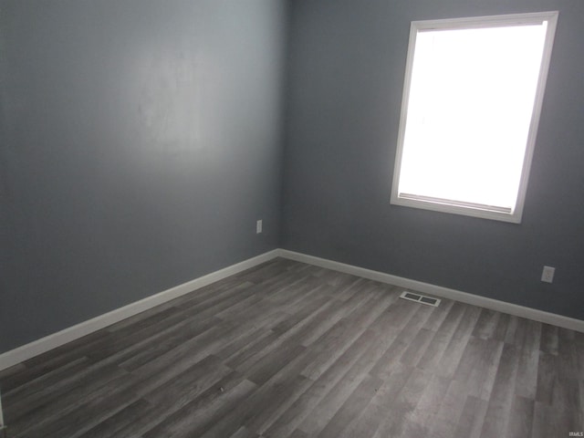 unfurnished room with dark hardwood / wood-style flooring