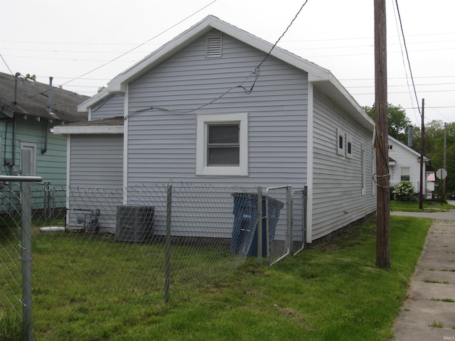 view of side of property featuring central AC and a lawn