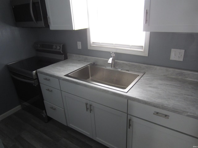 kitchen with sink, white cabinetry, electric stove, and dark wood-type flooring