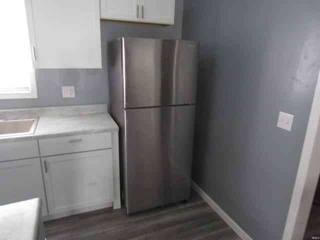 kitchen featuring dark hardwood / wood-style flooring, white cabinetry, and stainless steel fridge