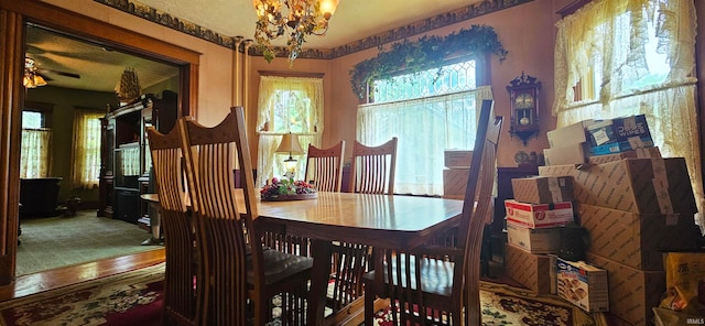 dining room with hardwood / wood-style flooring and ceiling fan with notable chandelier