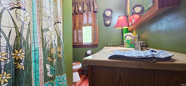 bathroom with hardwood / wood-style flooring, toilet, and vanity