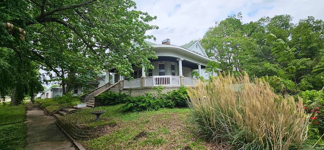 view of side of property featuring covered porch