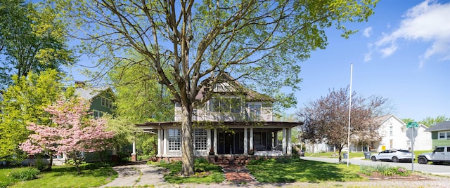 view of front of home with a porch and a front lawn