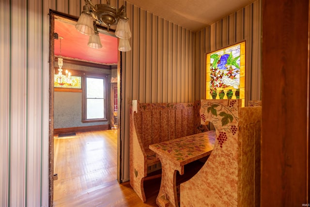 corridor featuring hardwood / wood-style floors and an inviting chandelier