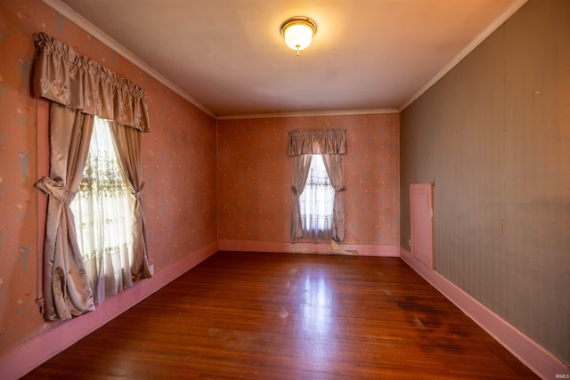 spare room featuring crown molding, dark wood-type flooring, and a notable chandelier