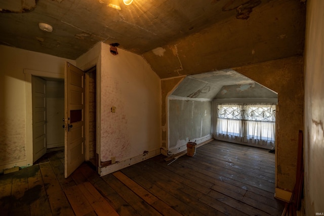 additional living space featuring lofted ceiling and dark wood-type flooring