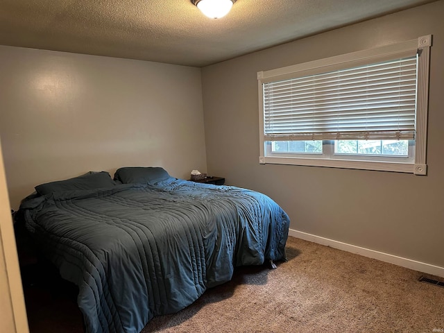 carpeted bedroom featuring a textured ceiling