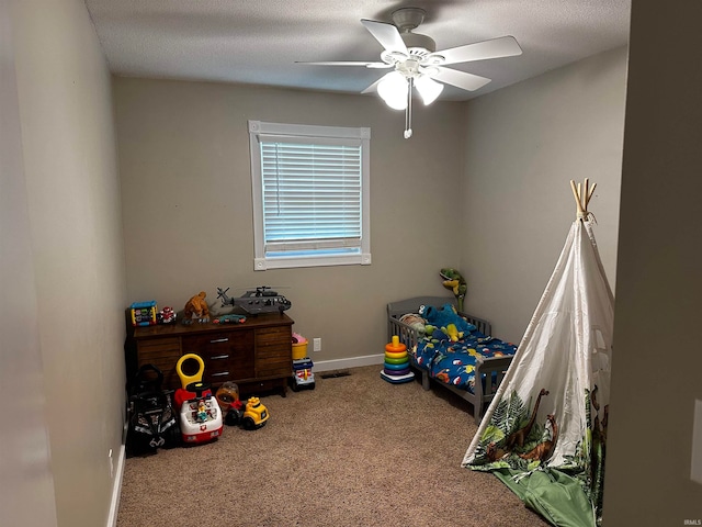 carpeted bedroom with ceiling fan and a textured ceiling