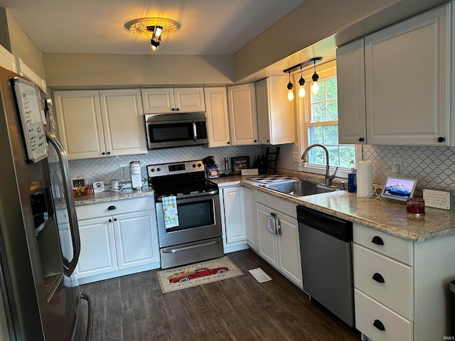 kitchen featuring stainless steel appliances, white cabinetry, dark hardwood / wood-style floors, and sink