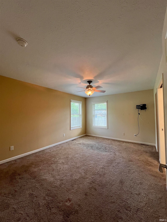 carpeted spare room featuring a textured ceiling and ceiling fan