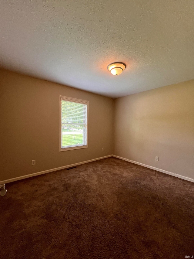 carpeted empty room with a textured ceiling