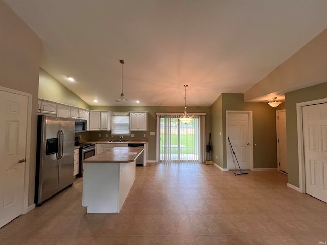 kitchen with a center island, decorative light fixtures, stainless steel appliances, sink, and vaulted ceiling