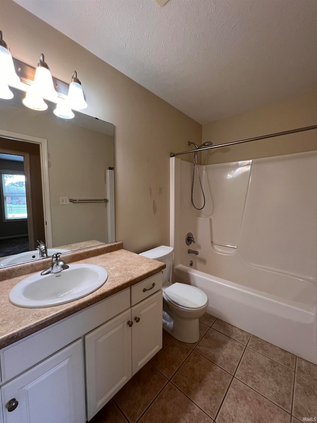 full bathroom featuring tile flooring, a textured ceiling, washtub / shower combination, toilet, and vanity