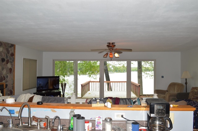 living room with ceiling fan and sink