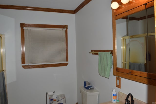 bathroom featuring ornamental molding, toilet, and sink