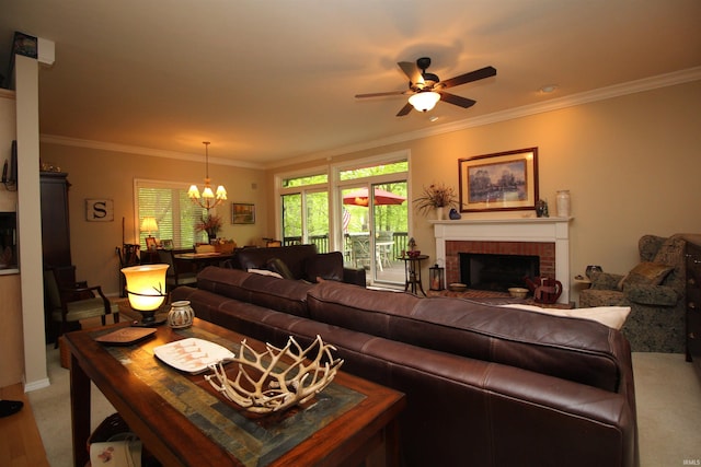 living room featuring crown molding, ceiling fan with notable chandelier, and a brick fireplace