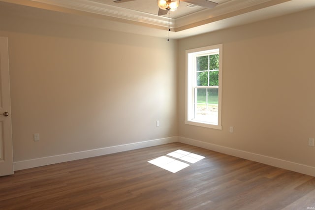 unfurnished room with hardwood / wood-style floors, ceiling fan, a raised ceiling, and crown molding