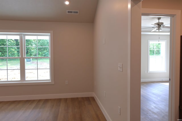 spare room with plenty of natural light, ceiling fan, and wood-type flooring