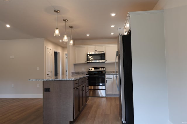 kitchen with decorative light fixtures, stainless steel appliances, white cabinets, and dark hardwood / wood-style floors