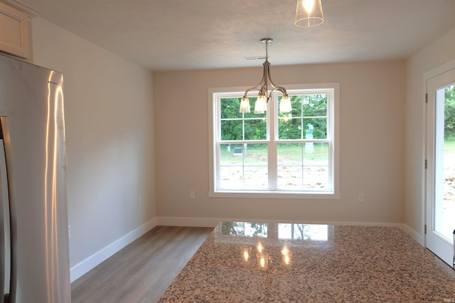 interior space featuring plenty of natural light, light hardwood / wood-style floors, and a notable chandelier