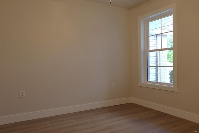 spare room with wood-type flooring and plenty of natural light